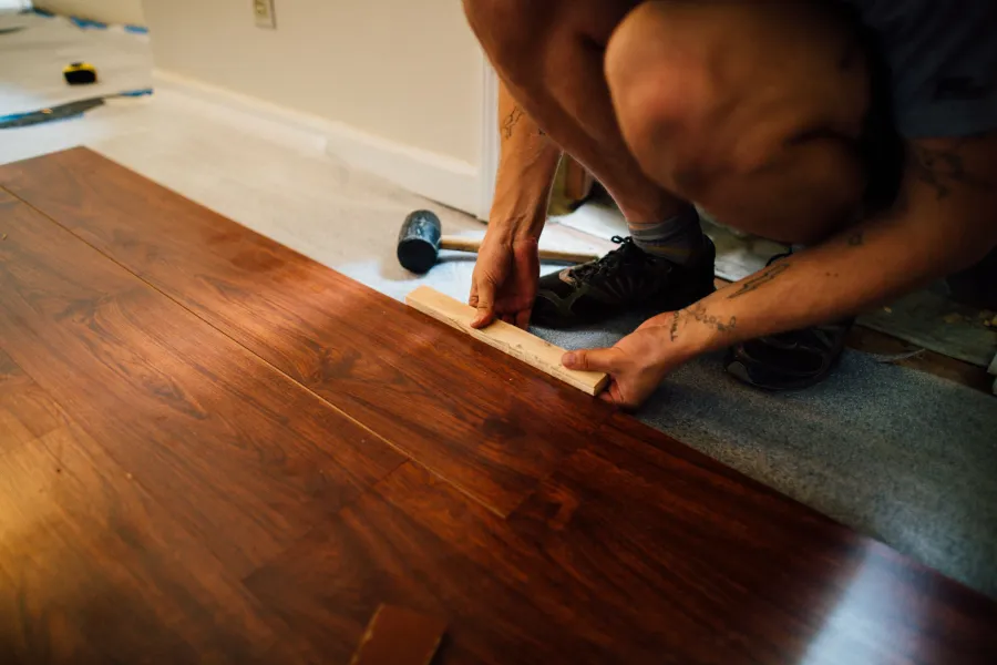 Installer fitting planks by hand